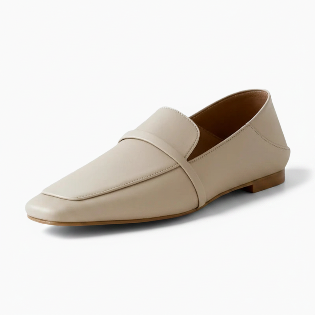 Mocassin crème pour femme en cuir souple, élégamment posé sur une surface lumineuse.