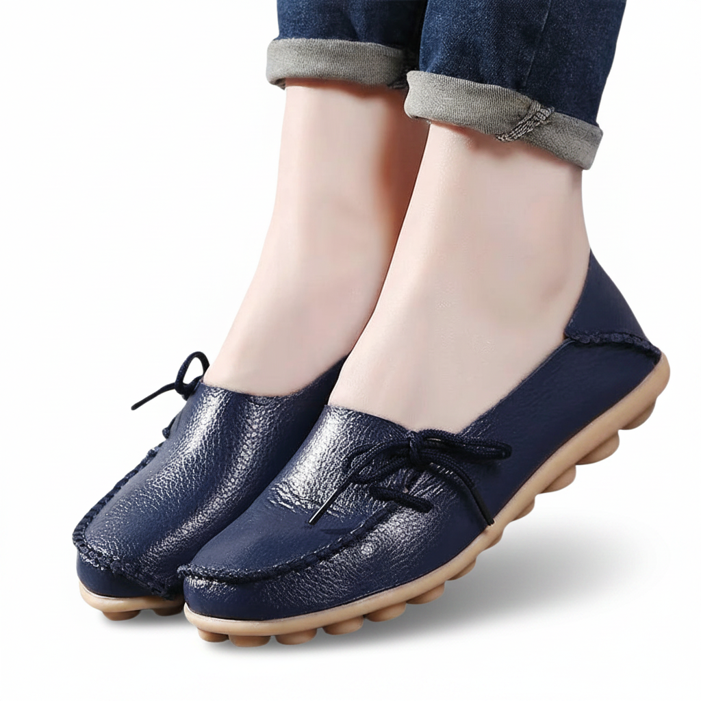 Pieds chaussés de mocassins bleu marine, associés à un pantalon de tailleur gris, pour un look professionnel.