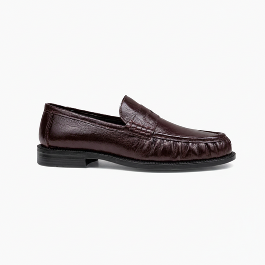 Détail du dessus du mocassin en cuir véritable, avec ses coutures délicates et sa couleur profonde.