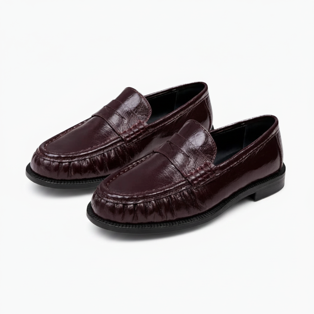 Mocassins bordeaux pour femme, vus d'en haut, portés avec un pantalon chic, évoquant une allure sophistiquée.