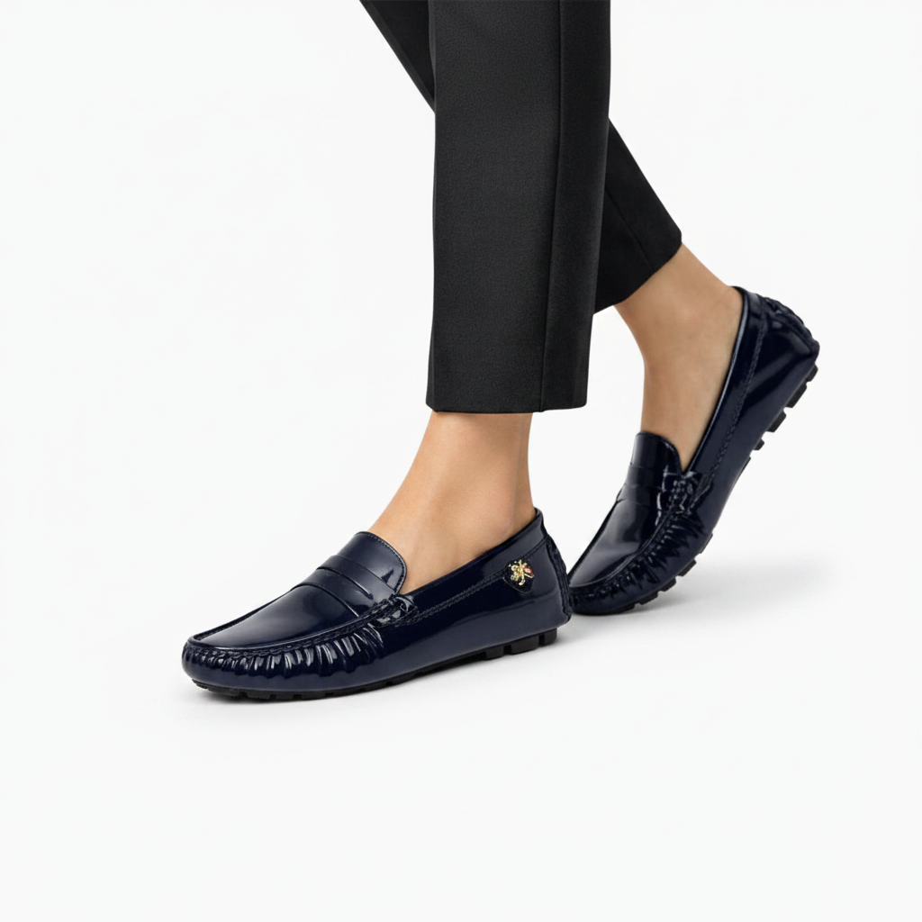 Chaussure vernie bleu marine au pied d'une femme, idéale pour un look sophistiqué au bureau.