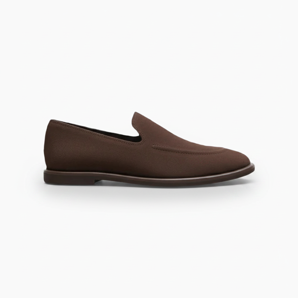 Vue plongeante sur une paire de mocassins en daim marron foncé, soulignant la coupe classique et la finition veloutée.