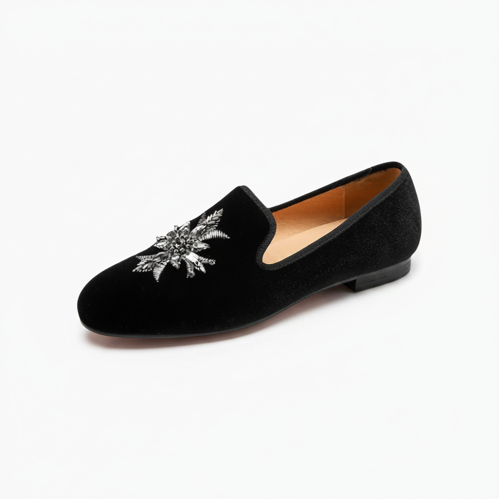 Mocassin en daim noir pour femme, une pièce raffinée avec détail floral argenté, parfaite pour le style.