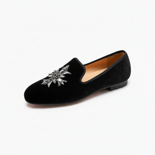 Mocassin en daim noir pour femme, une pièce raffinée avec détail floral argenté, parfaite pour le style.