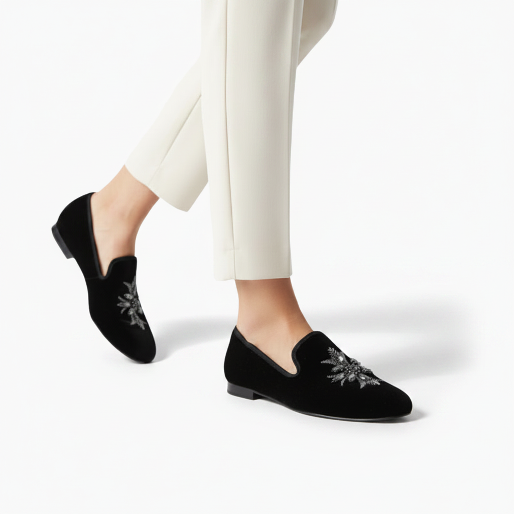 Vue latérale d'un élégant mocassin en daim noir, soulignant sa coupe classique et le design épuré.