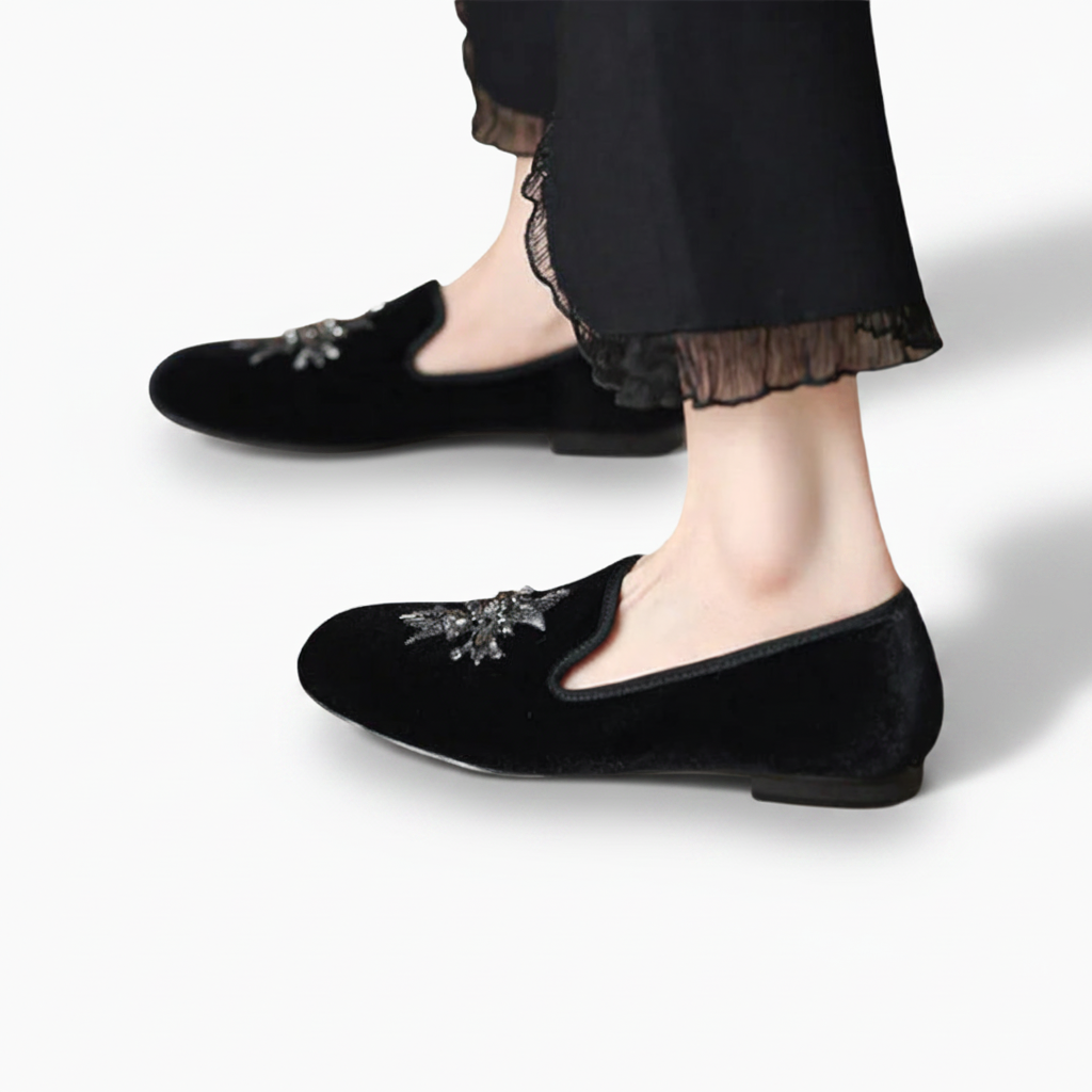 Paire de mocassins en daim noir posée sur une surface neutre, mettant en valeur leur texture veloutée et leur forme.
