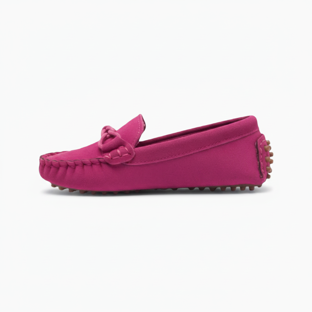 Vue latérale d'un mocassin rose pour enfant, révélant la douceur du daim et les finitions soignées.