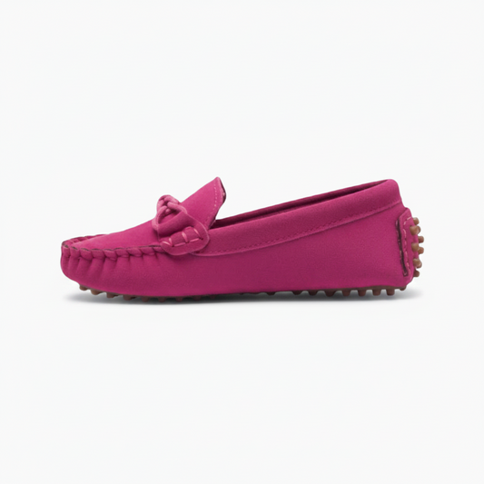 Vue latérale d'un mocassin rose pour enfant, révélant la douceur du daim et les finitions soignées.