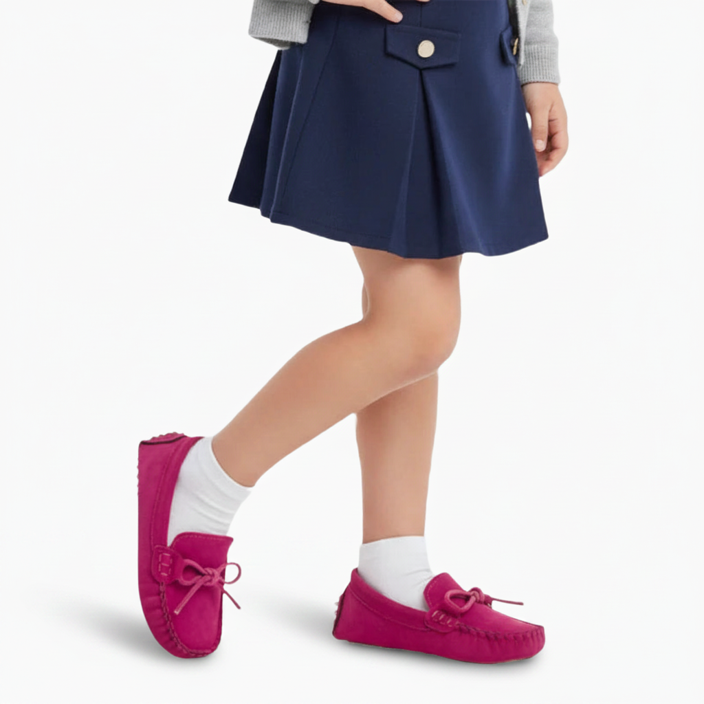 Mocassin rose plat en daim, orné de coutures délicates, un classique intemporel pour fillette.