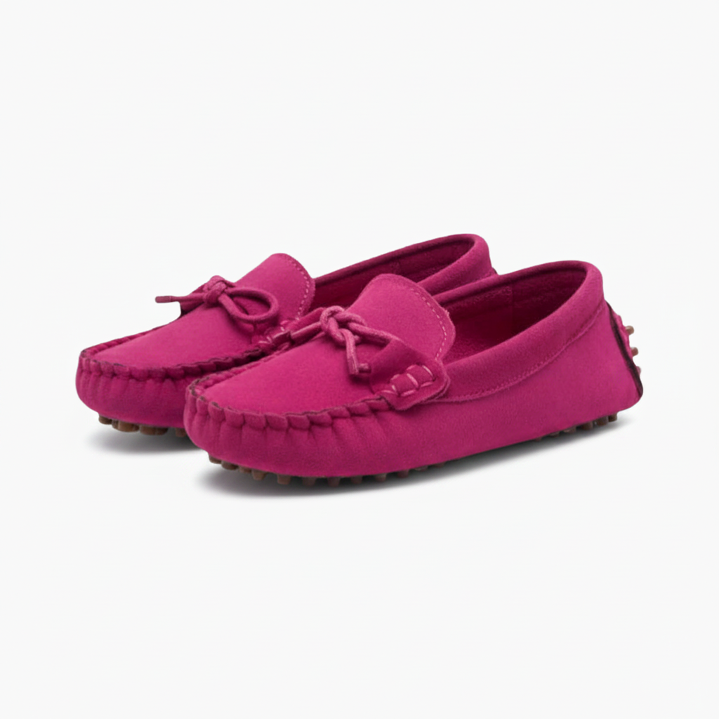 Enfant en jean décontracté, ses pieds chaussés de mocassins roses en daim ultra-confortables.