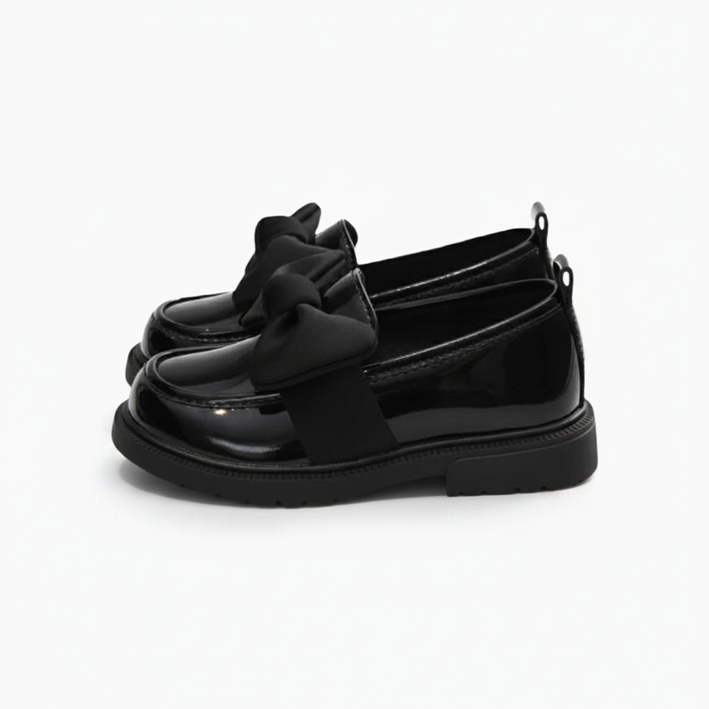 Vue de dessus d'un mocassin verni noir, mettant en valeur son délicat nœud papillon.