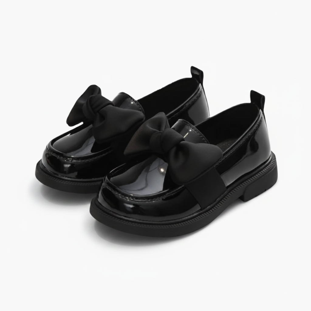 Mocassin classique pour fillette en cuir verni noir, prêt à compléter une tenue chic ou décontractée.