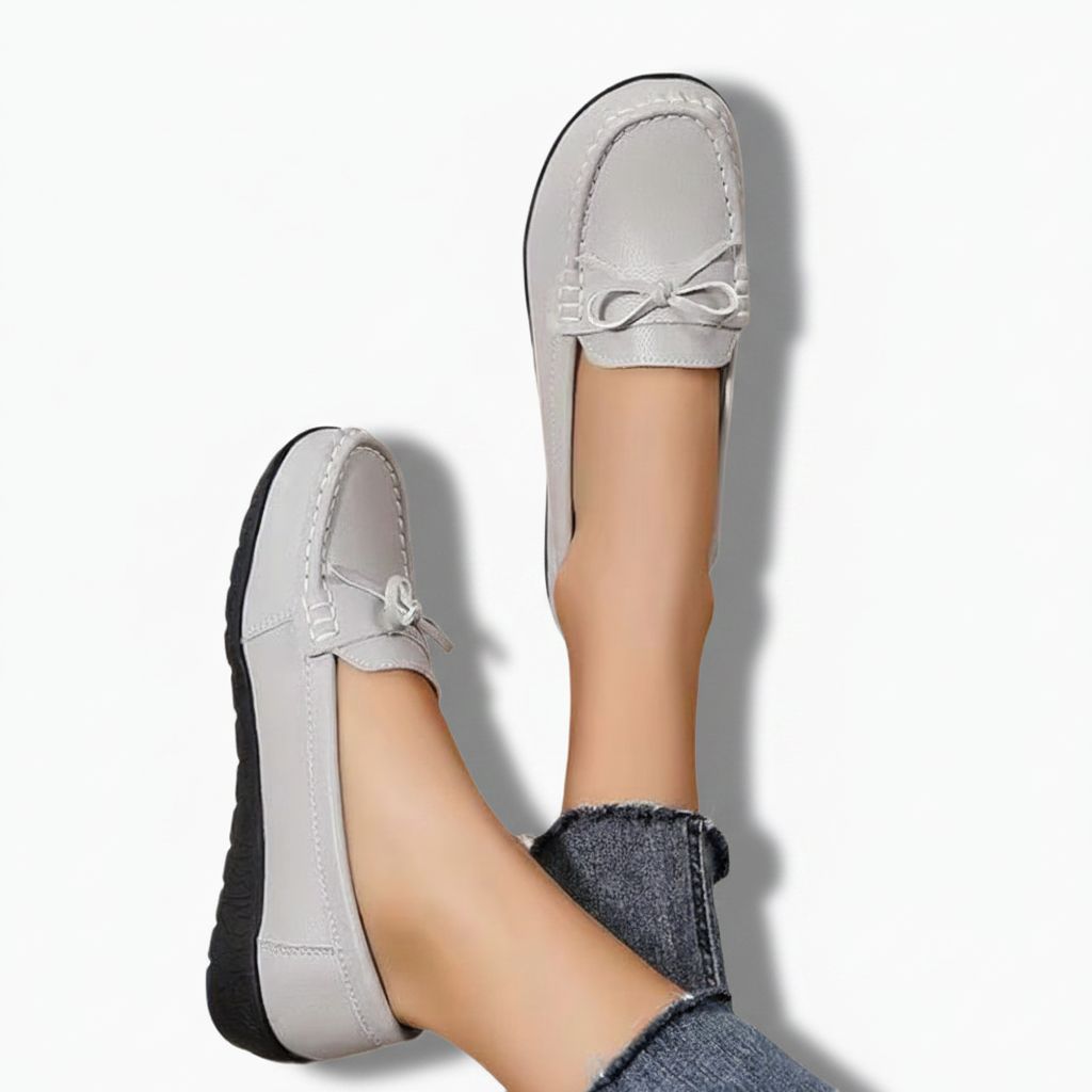 Pieds chaussés du mocassin gris et d'un jean décontracté, idéal pour une tenue de week-end sophistiquée.