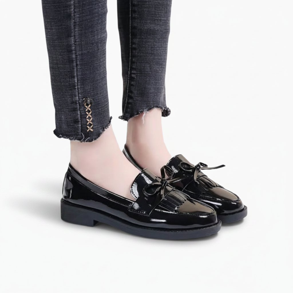 Mocassins noirs brillants portés avec un pantalon de tailleur, parfaits pour un look professionnel chic.