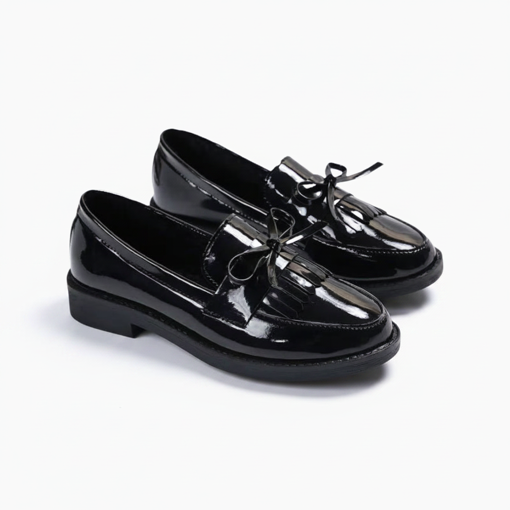 Mocassin femme noir brillant au repos, accentuant sa silhouette classique et son allure distinguée.