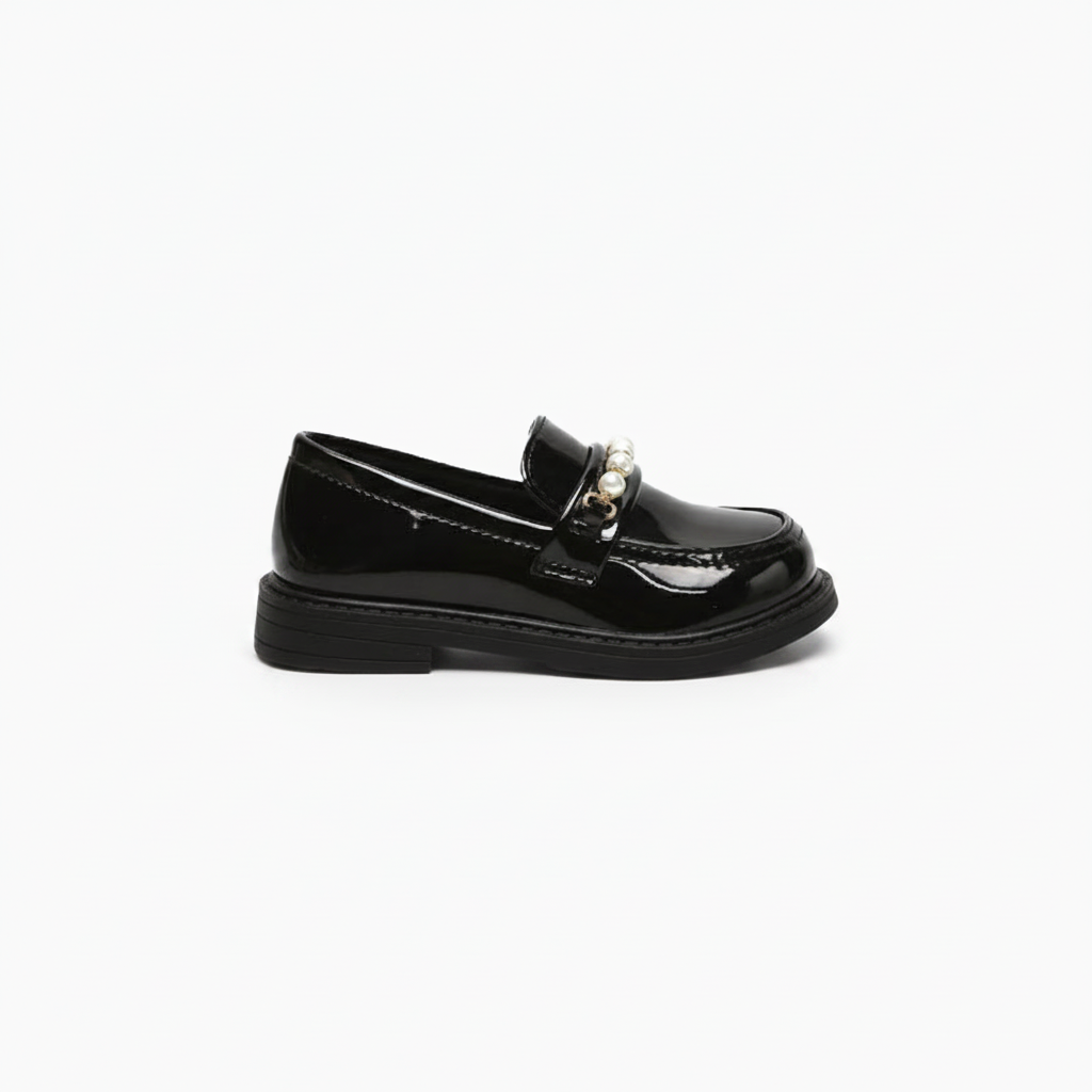 Vue de profil du mocassin noir fillette, révélant sa silhouette classique et sa semelle adhérente.