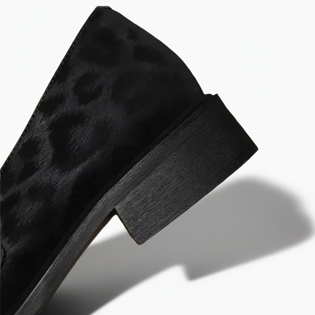 Finitions soignées et coutures précises du mocassin en cuir noir et léopard, témoignant d'une fabrication artisanale de quali