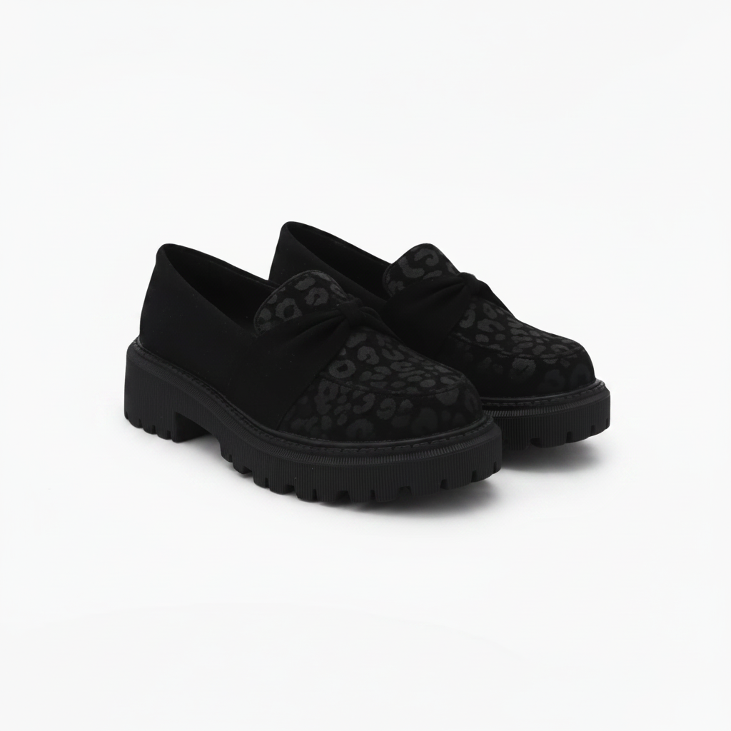 Mocassins noirs imprimé léopard portés avec un pantalon élégant, ajoutant une touche sauvage et chic à la tenue.
