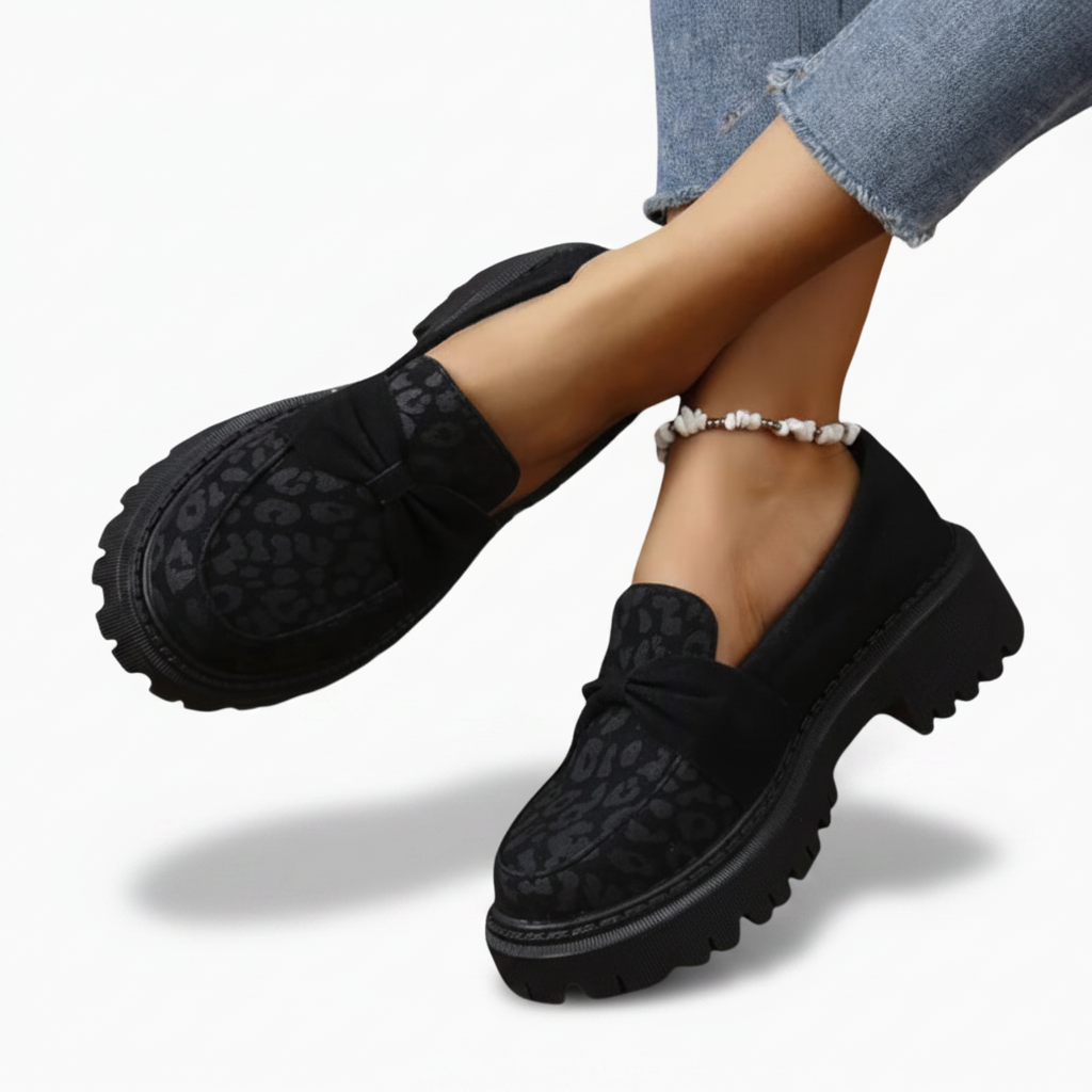 Rendu détaillé du bout des mocassins noirs femme, accentuant l'harmonie entre le noir profond et le motif félin.