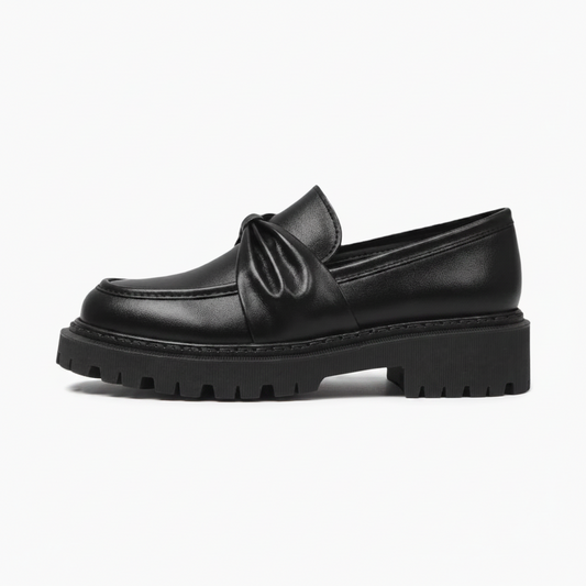 Détail raffiné du nœud féminin ornant le dessus du mocassin plateforme noir pour femme.