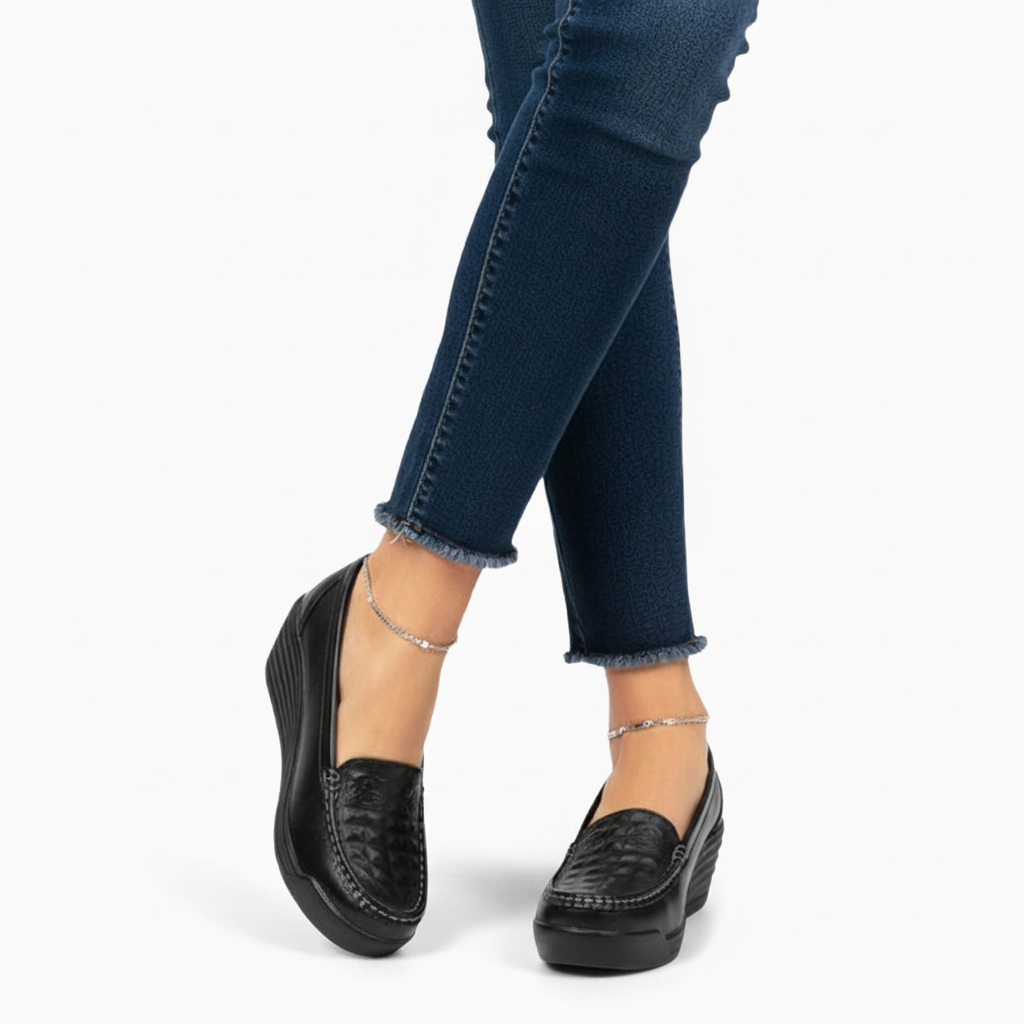 Mocassin plateforme en cuir noir porté par une femme, ajoutant une touche chic et contemporaine à sa tenue.