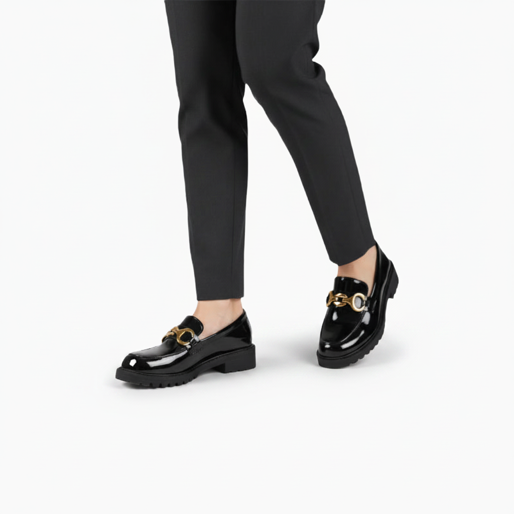 Mocassin plateforme noir vernis porté avec un pantalon stylé, incarnant l'élégance urbaine.