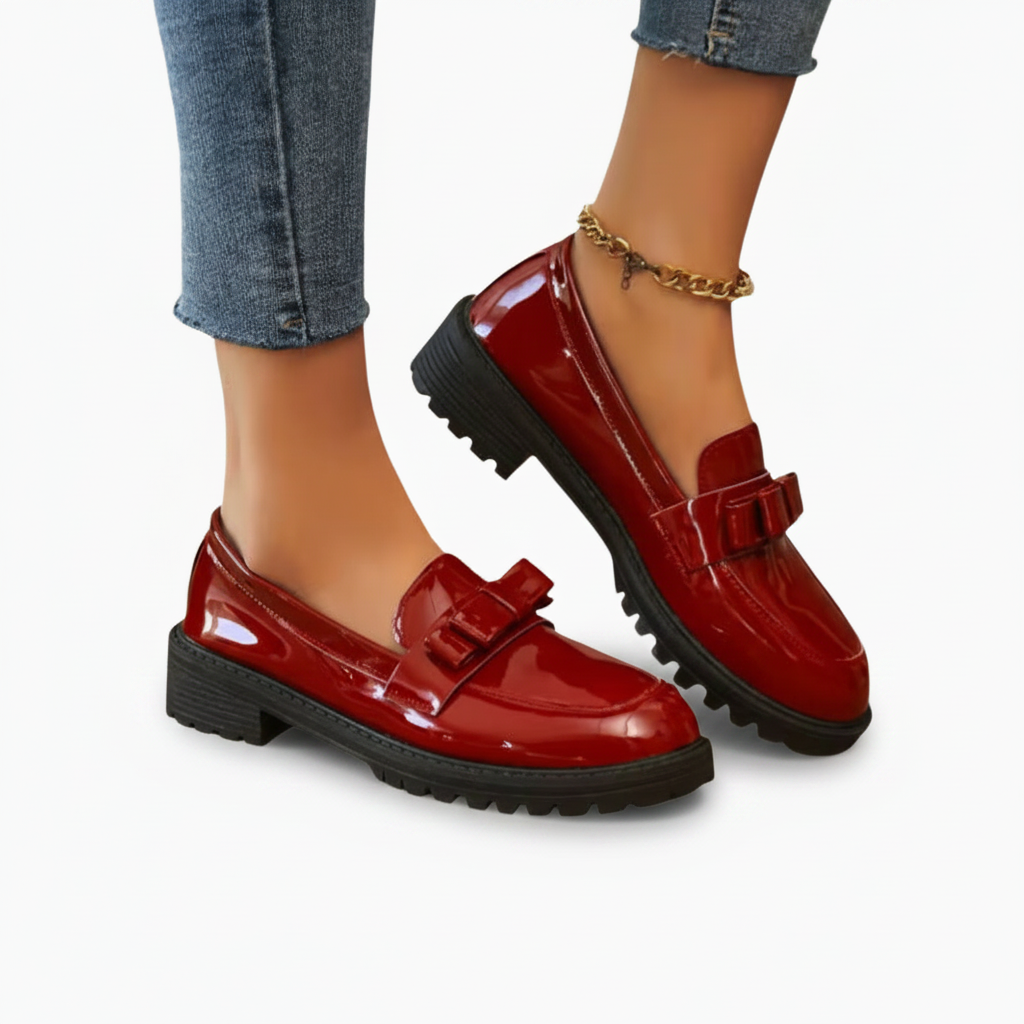 Gros plan sur le cuir verni et la texture lisse des mocassins rouges brillants, signe de leur qualité supérieure.