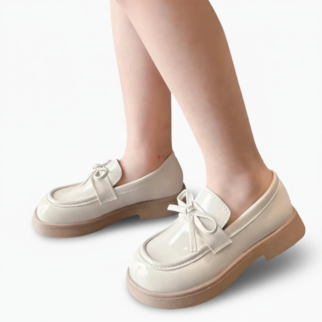 Vue de dessus d'un mocassin verni beige, mettant en valeur sa finition lisse et chic pour jeune fille.