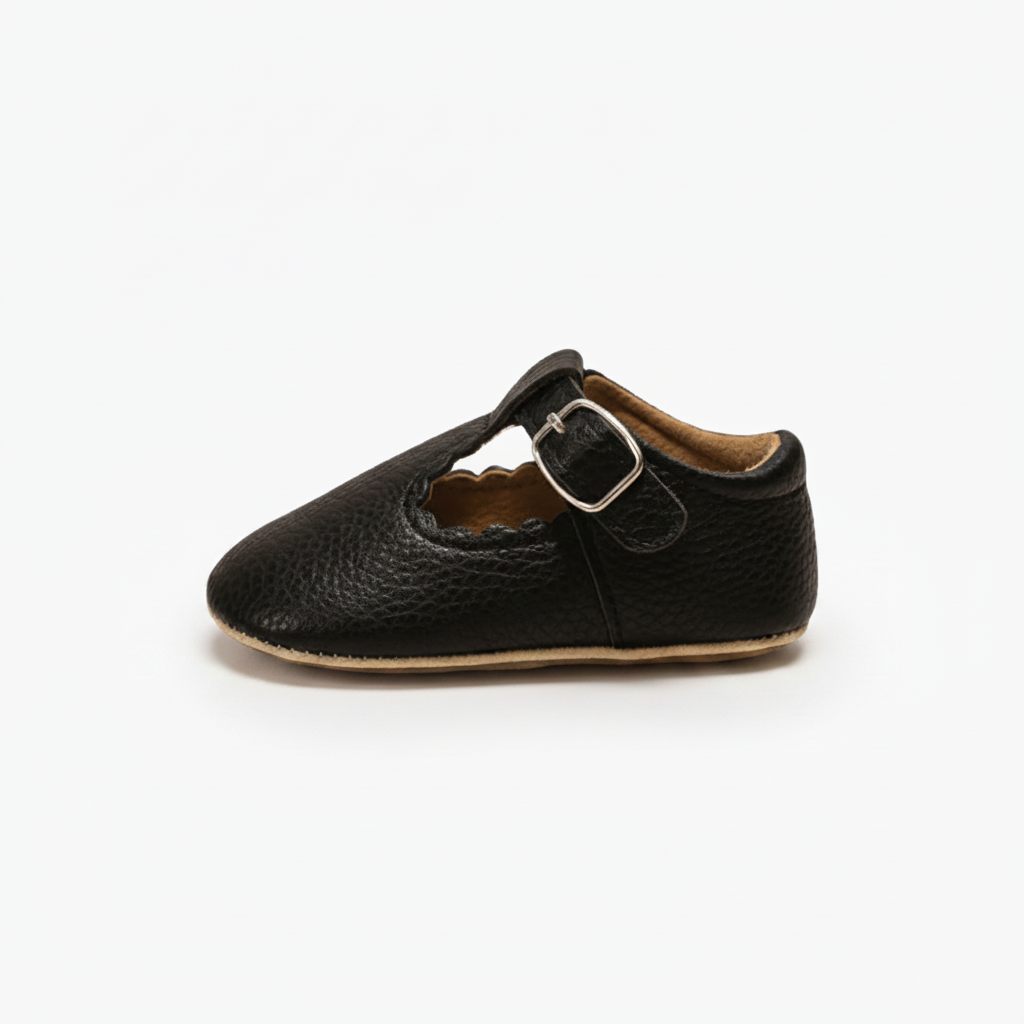 Profil latéral des mocassins bébé noirs, mettant en avant leur souplesse et design intemporel.